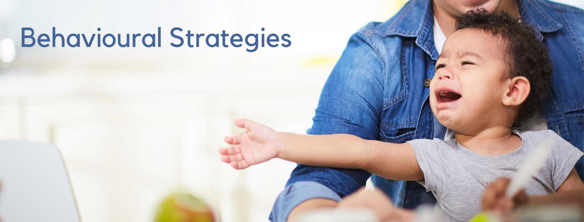 small boy crying in an adults arms