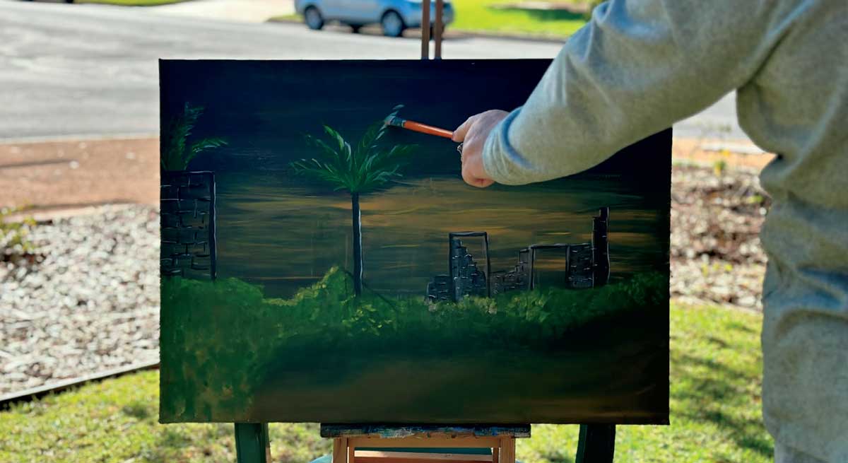 Man painting at the Riverland Homelessness exhibition